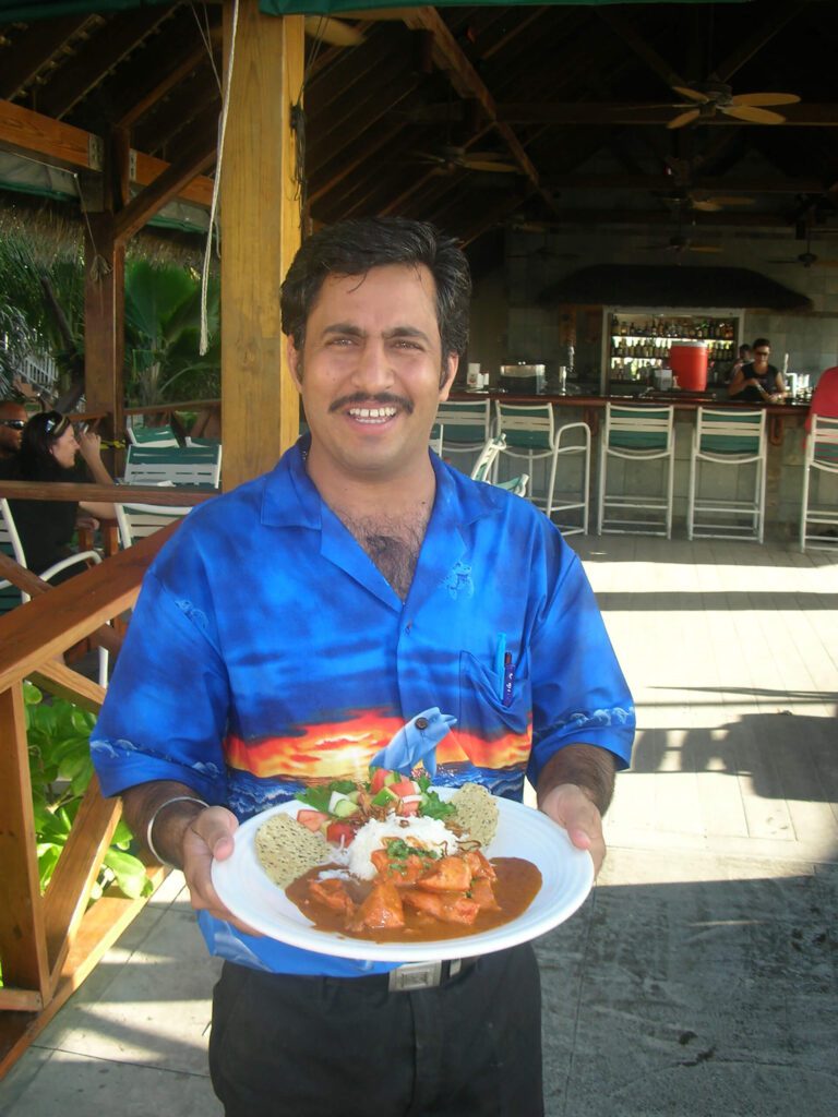 Waiter in blue serving Indian cuisine